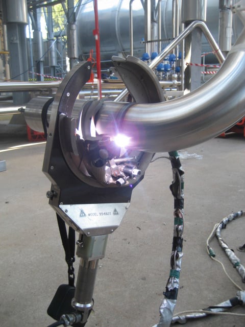 Orbital welding head performing a weld on stainless steel tube